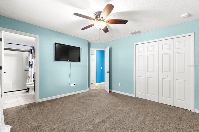 unfurnished bedroom with light carpet, ensuite bathroom, a closet, and ceiling fan