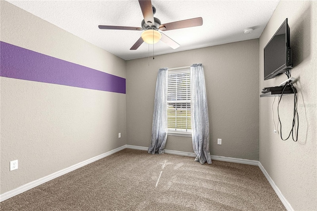 carpeted spare room with a textured ceiling and ceiling fan