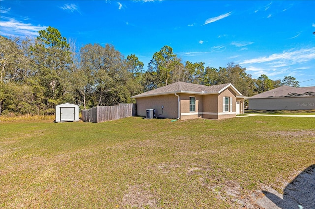 exterior space with a lawn, a shed, and central AC