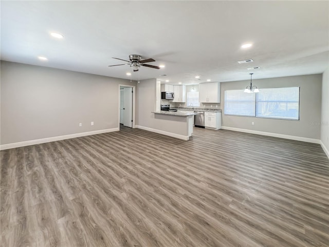 unfurnished living room with ceiling fan, dark hardwood / wood-style flooring, and sink