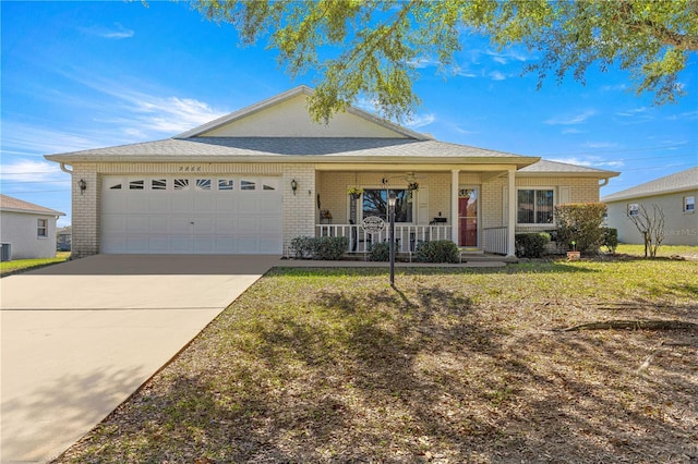 ranch-style home with covered porch, a front yard, and a garage