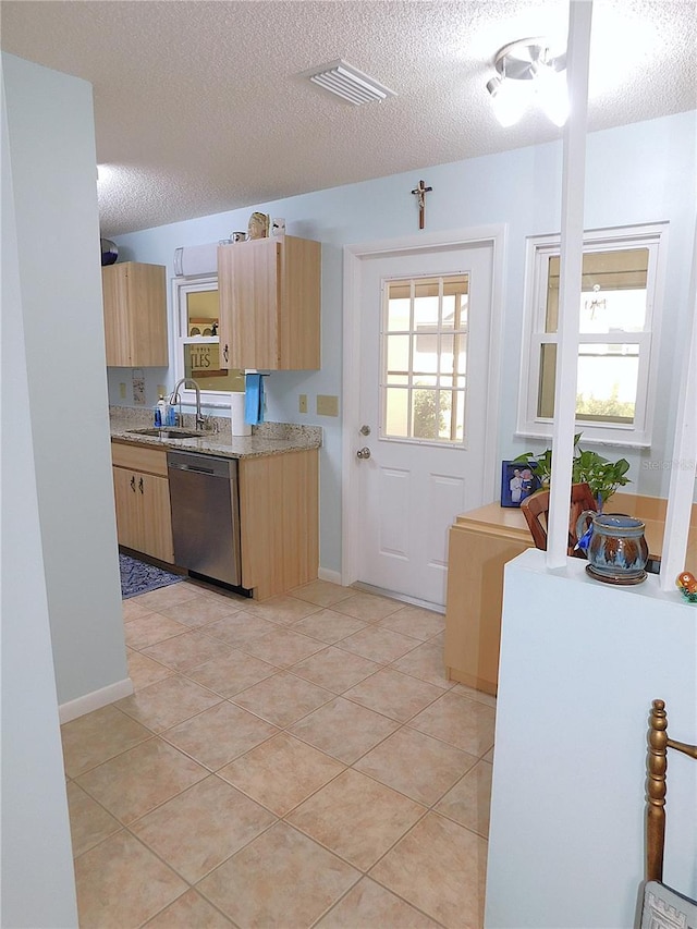 kitchen with dishwasher, a textured ceiling, light brown cabinets, light tile patterned floors, and sink