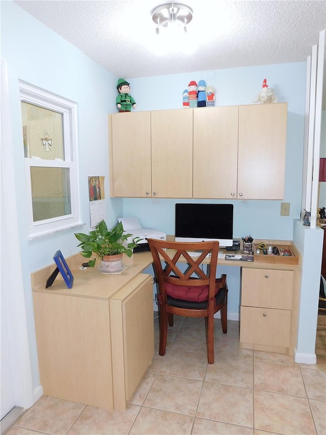 home office with light tile patterned floors, built in desk, and a textured ceiling