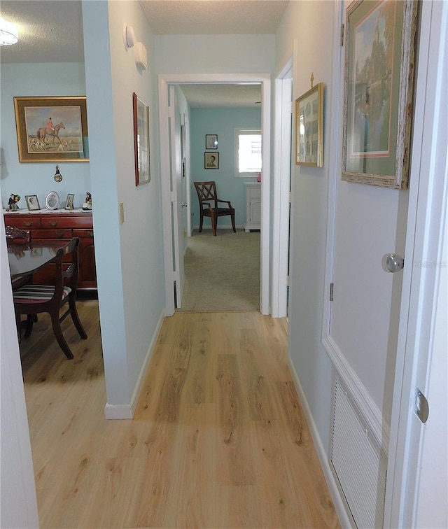 corridor with light hardwood / wood-style floors