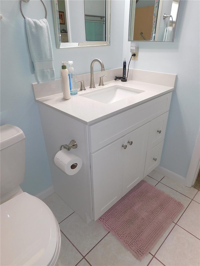 bathroom featuring vanity, tile patterned flooring, and toilet