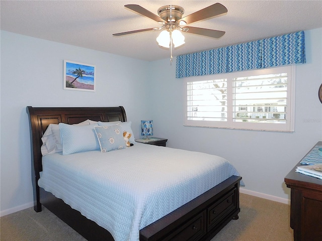 bedroom with a textured ceiling, ceiling fan, and light colored carpet