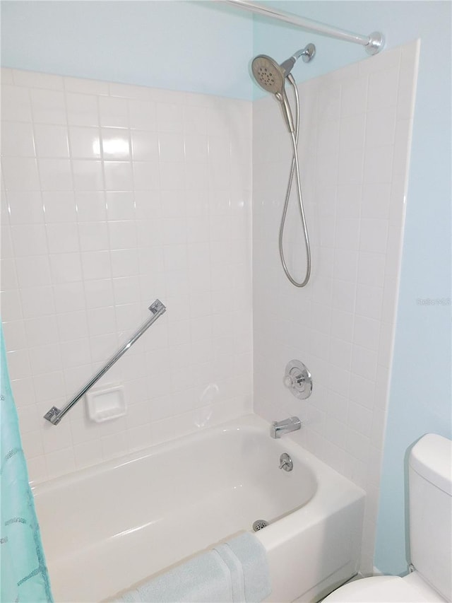 bathroom with shower / tub combo with curtain and toilet