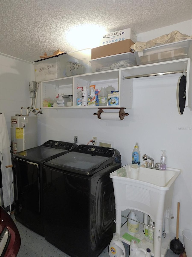 laundry room featuring independent washer and dryer, water heater, sink, and a textured ceiling