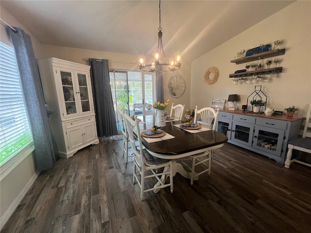 dining room with lofted ceiling, a notable chandelier, dark wood finished floors, and baseboards