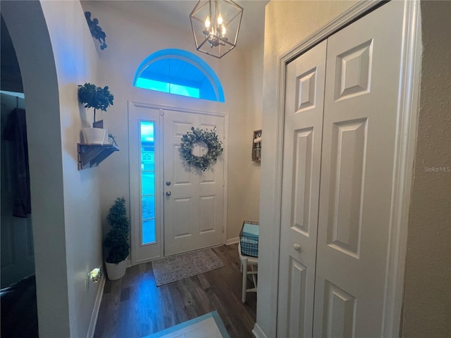 entryway featuring a notable chandelier, dark wood finished floors, and baseboards