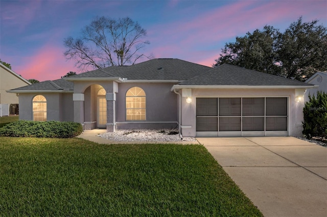 ranch-style house with an attached garage, a front lawn, concrete driveway, and stucco siding