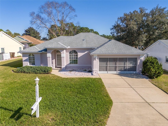 ranch-style house with a garage, a shingled roof, concrete driveway, stucco siding, and a front yard