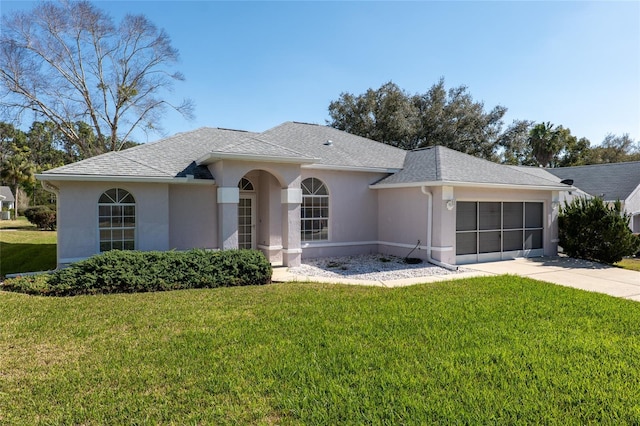 single story home featuring a garage, a shingled roof, a front lawn, and stucco siding