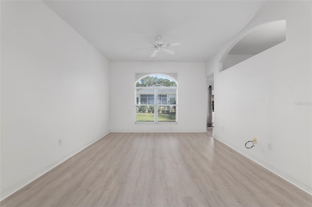 spare room featuring light wood-style floors, baseboards, and a ceiling fan