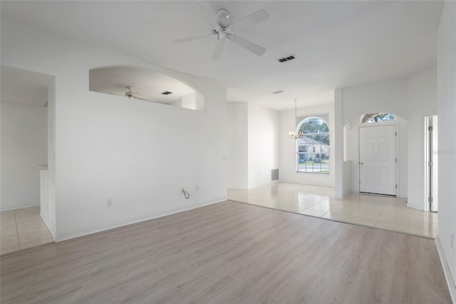 interior space featuring ceiling fan with notable chandelier, light wood-style flooring, and visible vents