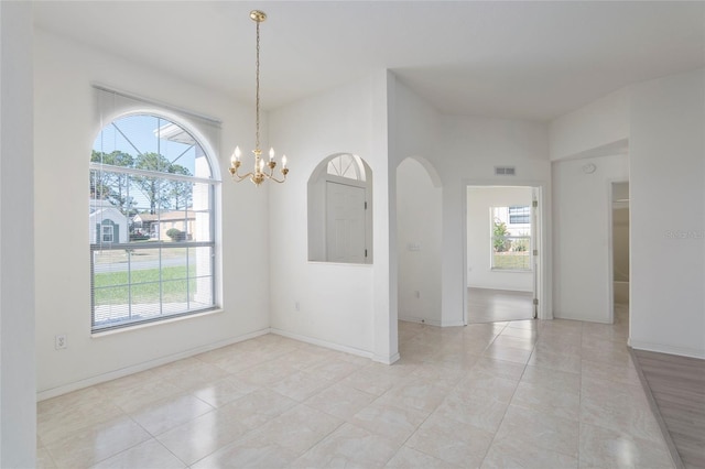 spare room featuring plenty of natural light, visible vents, and baseboards