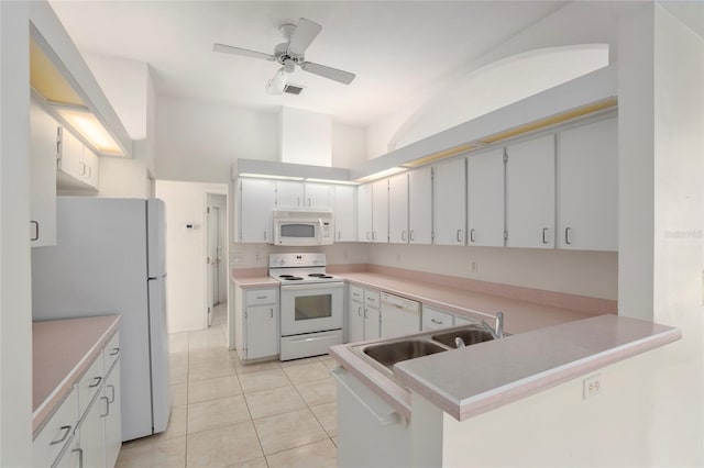 kitchen featuring a peninsula, white appliances, light countertops, and white cabinets