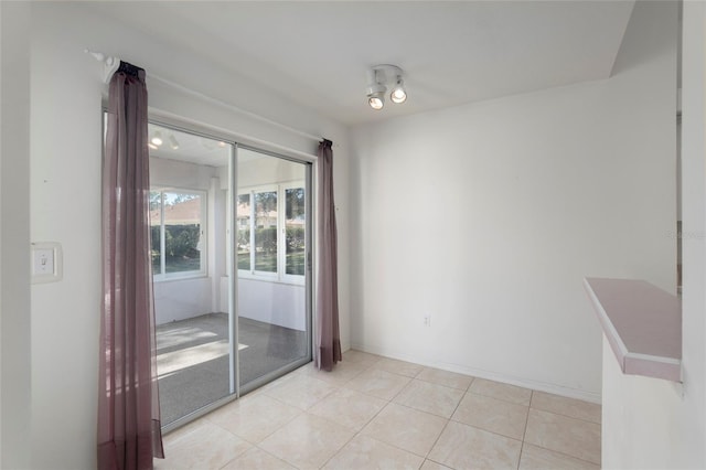 unfurnished room featuring light tile patterned flooring and baseboards