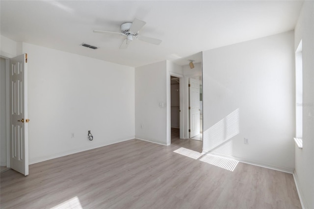 empty room with light wood-type flooring, baseboards, visible vents, and a ceiling fan