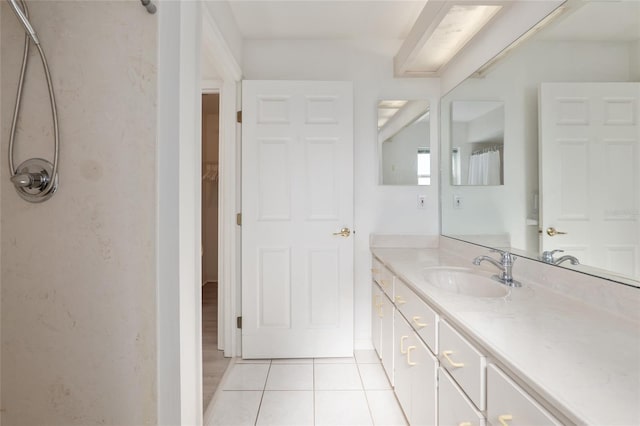 full bath featuring tile patterned flooring, vanity, and walk in shower