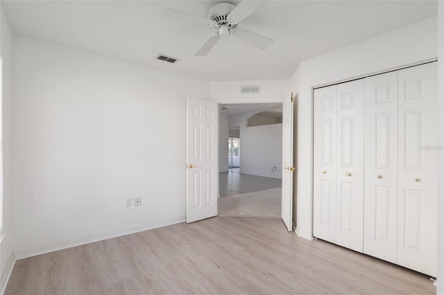 unfurnished bedroom with a closet, visible vents, baseboards, and light wood finished floors