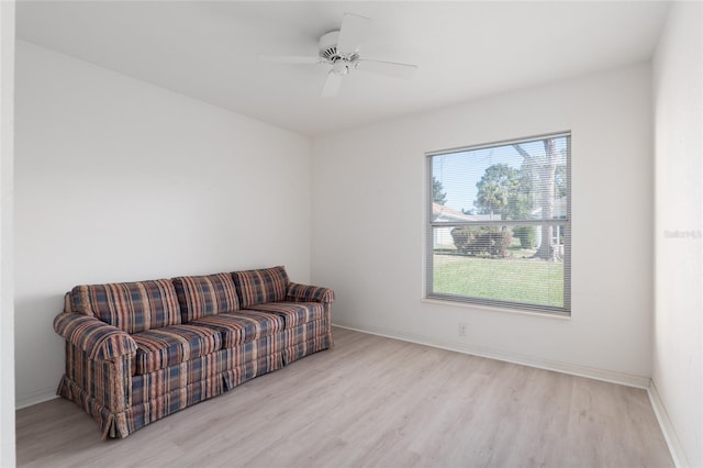 sitting room with light wood-type flooring, ceiling fan, and baseboards