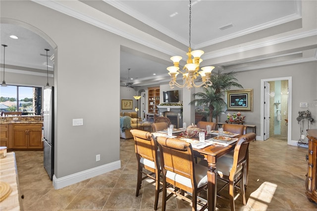 dining space featuring ceiling fan with notable chandelier, a tray ceiling, and crown molding