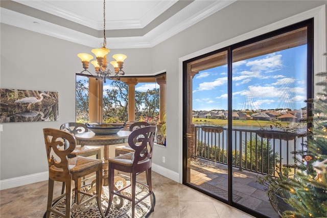 dining area featuring ornamental molding, a water view, a chandelier, and a raised ceiling