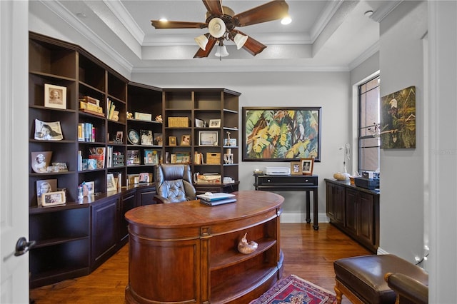 office space with ornamental molding, dark hardwood / wood-style floors, ceiling fan, and a raised ceiling