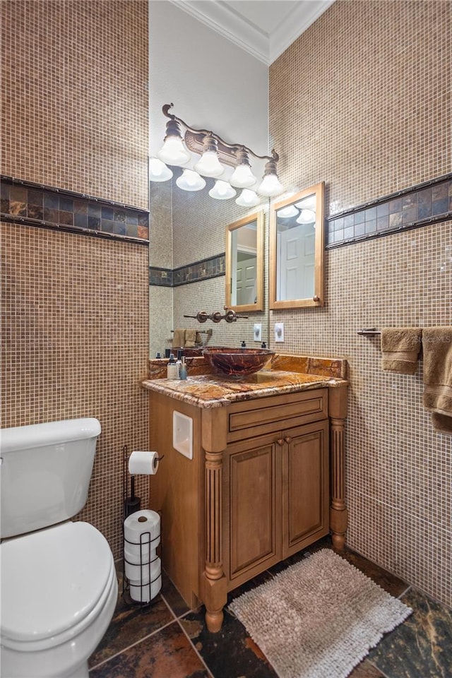 bathroom with tile walls, ornamental molding, vanity, and toilet