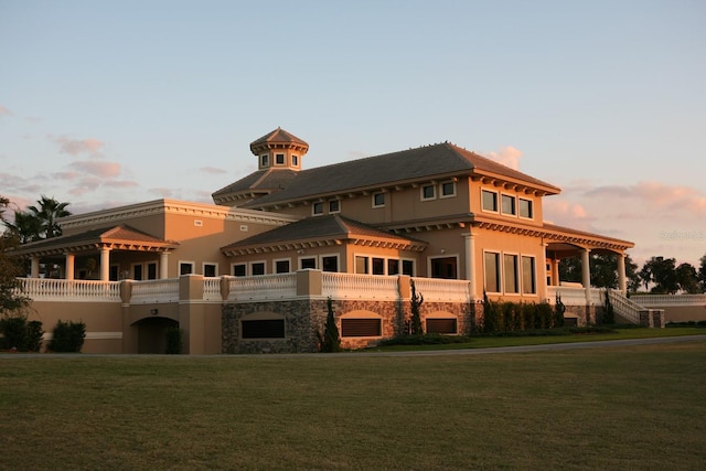 back house at dusk with a lawn