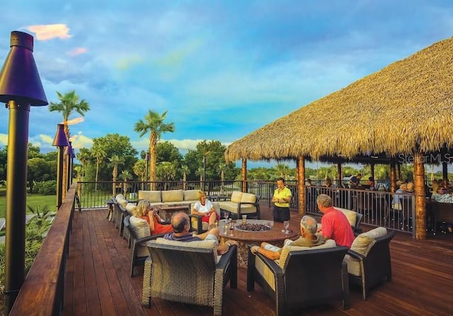 wooden terrace with an outdoor living space with a fire pit and a gazebo