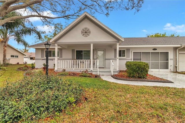 view of front of property featuring a porch, an attached garage, concrete driveway, stucco siding, and a front yard