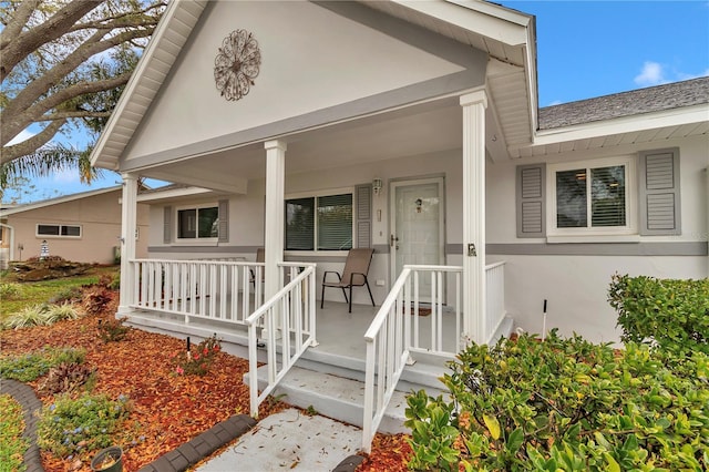 property entrance featuring a porch and stucco siding