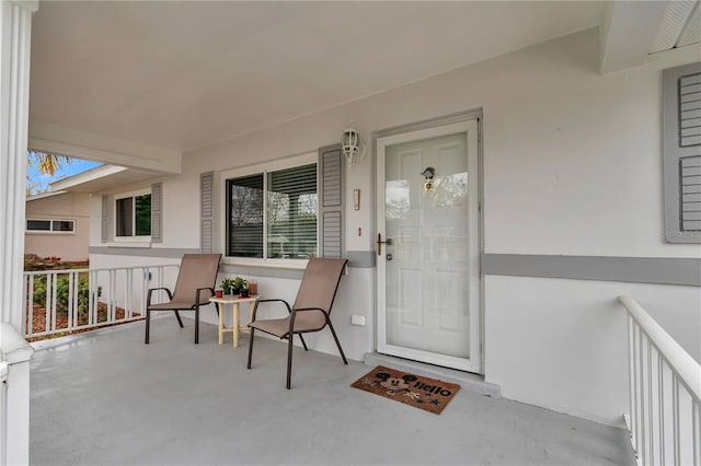 view of exterior entry with covered porch and stucco siding