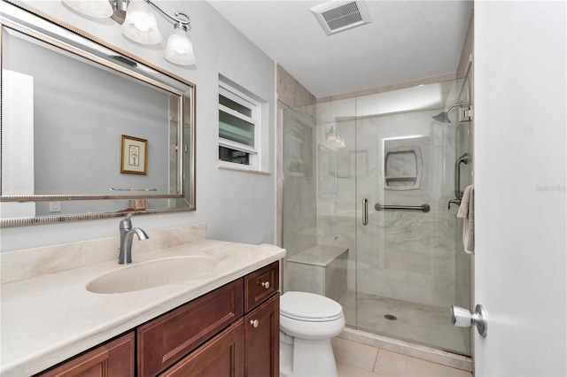 bathroom featuring tile patterned flooring, toilet, vanity, visible vents, and a shower stall