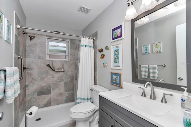 full bath featuring toilet, visible vents, tiled shower, and vanity