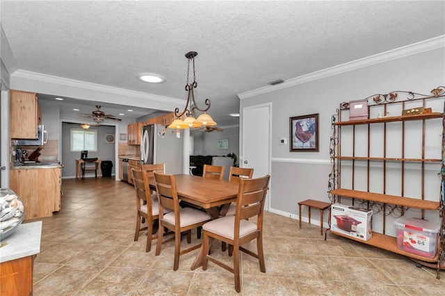 dining space with ceiling fan, a textured ceiling, visible vents, baseboards, and ornamental molding