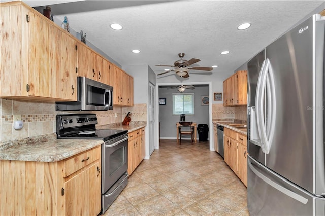 kitchen featuring a textured ceiling, stainless steel appliances, tasteful backsplash, and light countertops