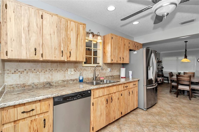 kitchen with visible vents, appliances with stainless steel finishes, a sink, and light brown cabinetry