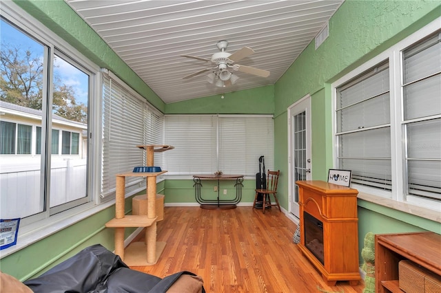 sunroom / solarium with a ceiling fan, lofted ceiling, and visible vents