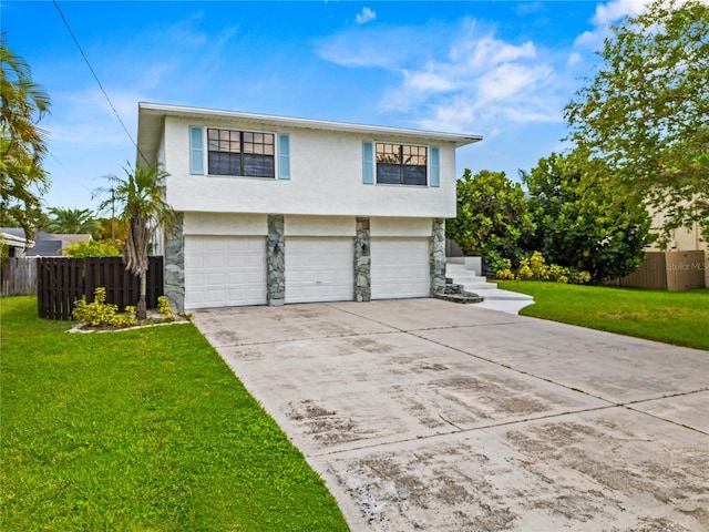 view of front of property with stucco siding, a front yard, fence, a garage, and stone siding