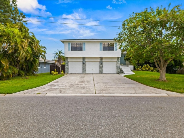 view of front facade with an attached garage, concrete driveway, stone siding, stucco siding, and a front yard