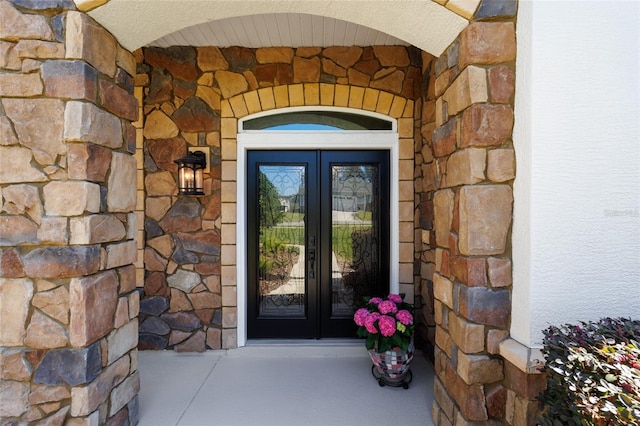 view of exterior entry with french doors and stone siding
