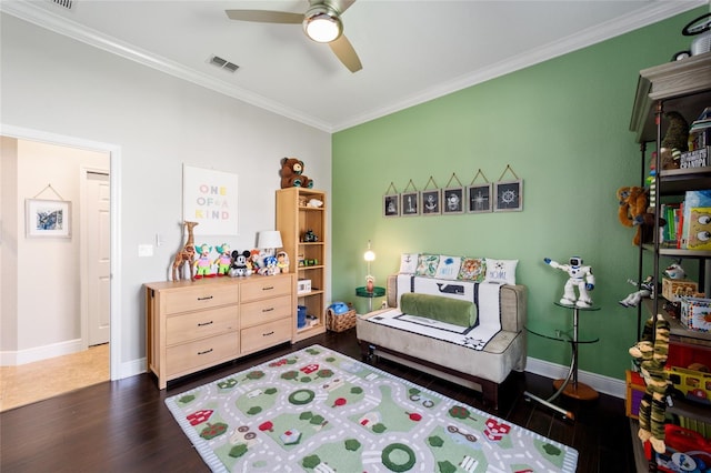 bedroom with crown molding, ceiling fan, visible vents, baseboards, and wood finished floors