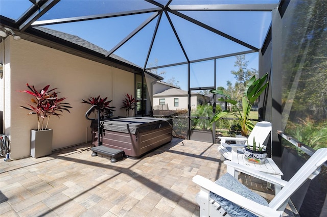 view of patio / terrace with a lanai and a hot tub