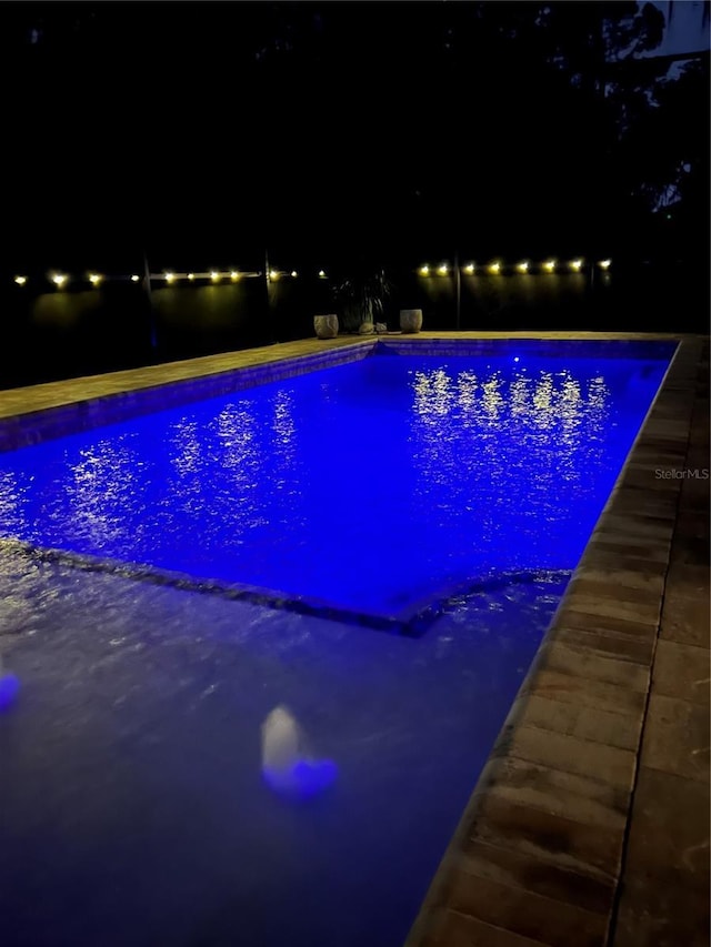 pool at night featuring an outdoor pool
