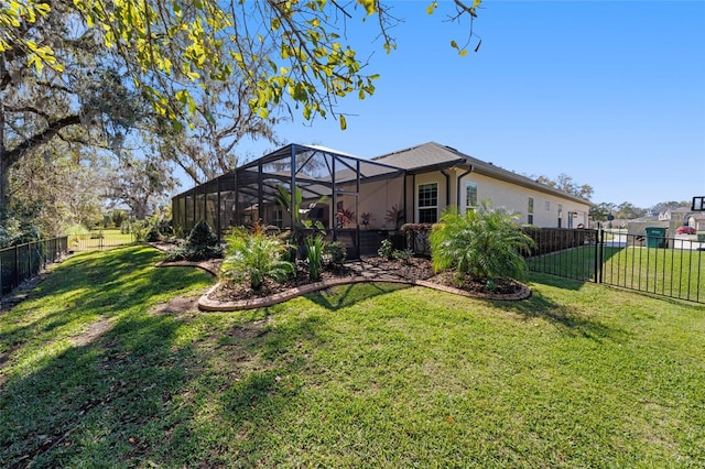 back of house featuring a lanai, fence, stucco siding, and a lawn