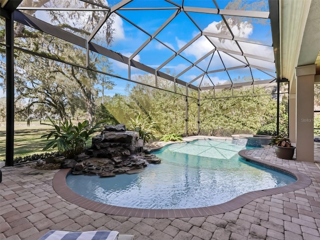 view of pool with an in ground hot tub, glass enclosure, and a patio