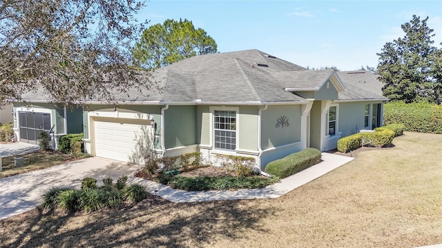 view of front of property featuring a garage, driveway, a front yard, and stucco siding